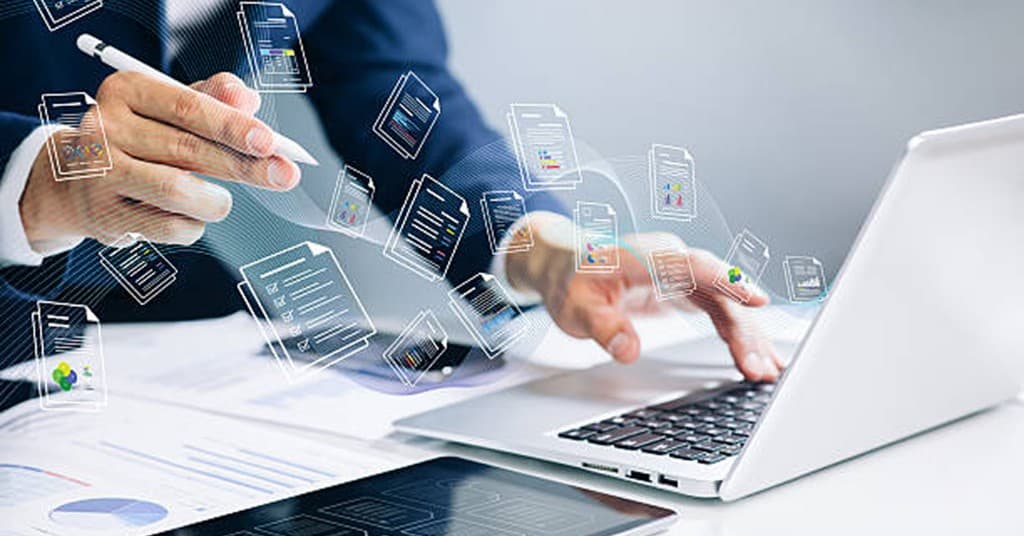 Business professional managing digital documents and invoices across laptop and tablet