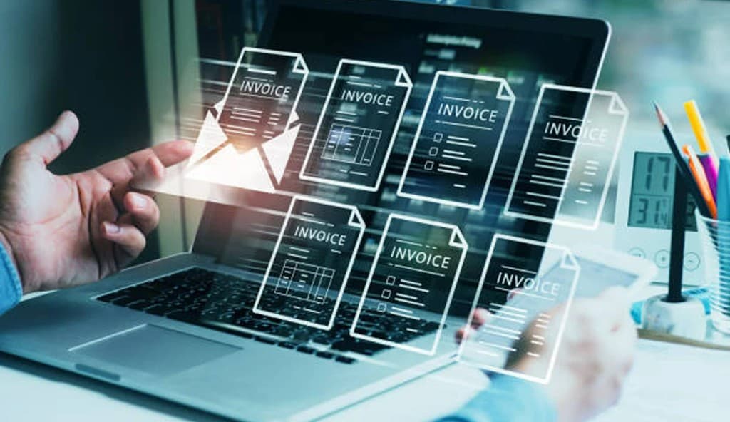 Floating digital invoice documents above a laptop on a desk